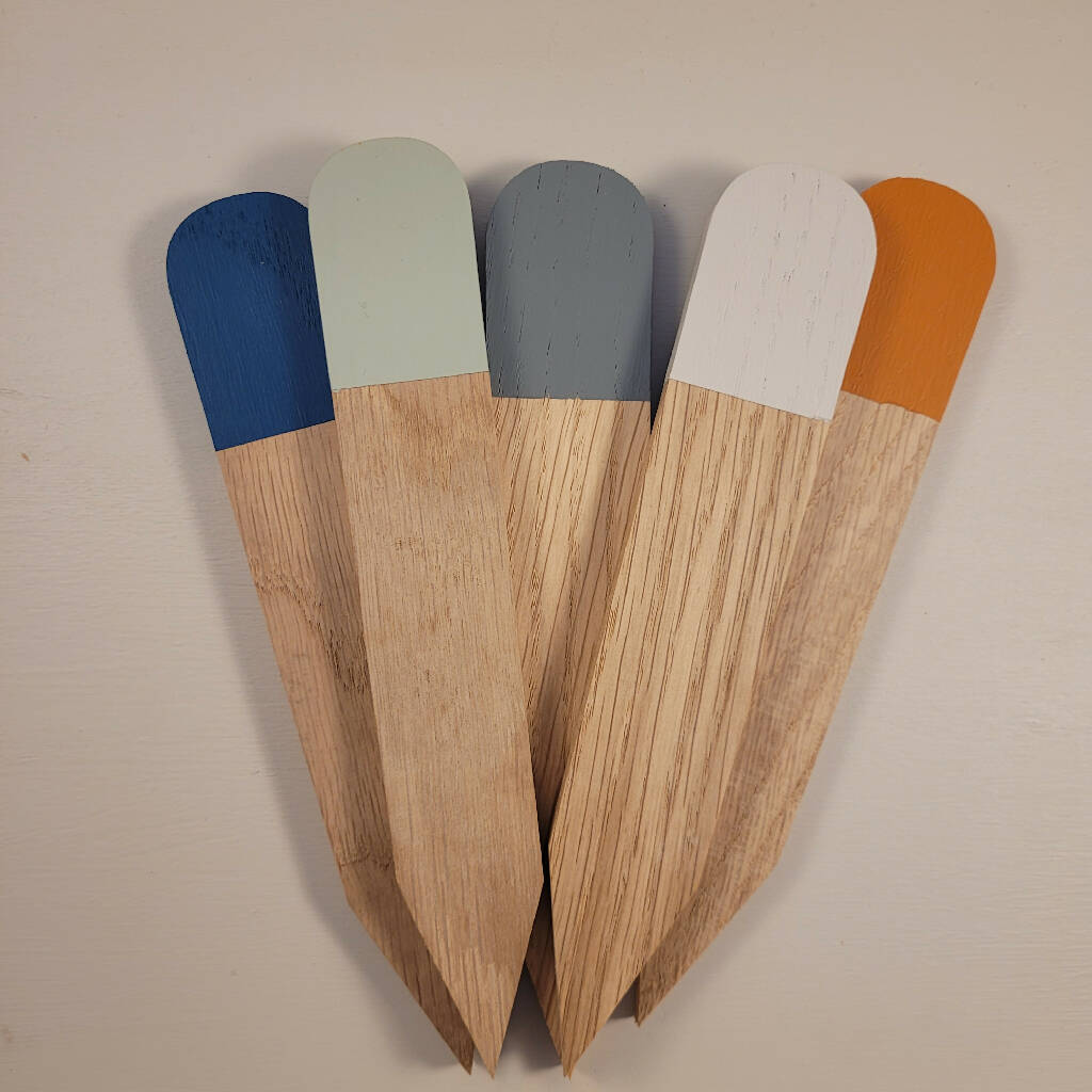 a woman in a white top and blue jeans leaning against a wall